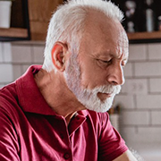 Elderly gentleman in kitchen looking at something